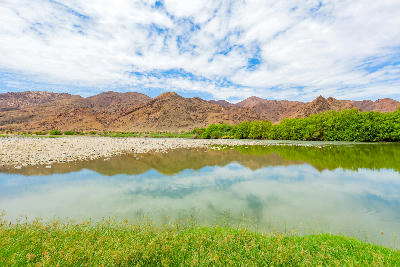 The Orange River flowing through the mountainous Richtersveld landscape at sunset.