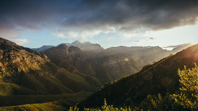 Sun rays illuminating the mountain slopes and valley landscape in Jonkershoek Nature Reserve near Stellenbosch, Cape Winelands, South Africa.