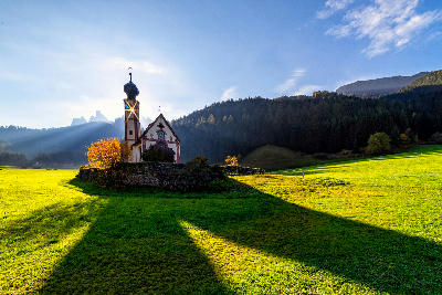 St. Johann Church near Santa Maddalena in Val di Funes, set within alpine meadows beneath the peaks of the Dolomites.