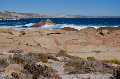 Pink granite rock formations and Atlantic waves along the coastline of Cape Columbine Nature Reserve near Tietiesbaai, South Africa.