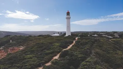 Aerial view of Cape Otway Lighthouse, walking path and coastal vegetation above the Southern Ocean in Victoria.