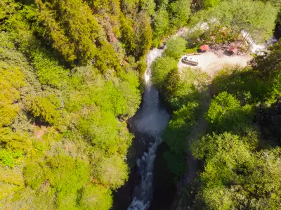 Aerial view of Palovit Waterfall plunging through a narrow gorge surrounded by dense green forest in the Kaçkar Mountains of Rize, Turkey.