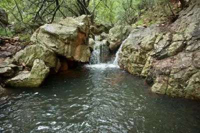 Seasonal rock pool and small waterfall among boulders in the Vredefort Dome World Heritage Site, South Africa.