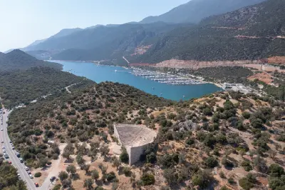 Aerial view of the Antiphellos Ancient Theatre in Kaş, Antalya, Turkey, with the stone amphitheater, turquoise Mediterranean bay, marina, and surrounding mountains.