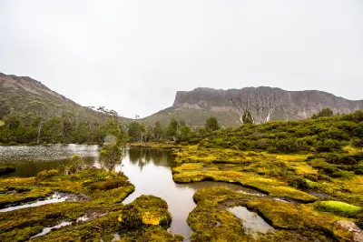 Pool of Bethesda surrounded by alpine vegetation and dolerite cliffs in Walls of Jerusalem National Park, Tasmania.