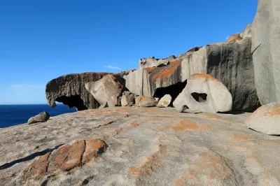 Sculpted granite boulders with unusual hollows, overhanging shapes and orange lichen at Remarkable Rocks overlooking the Southern Ocean, Kangaroo Island.
