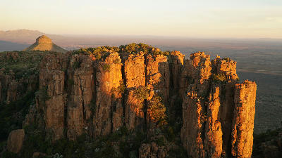 Golden sunset light illuminating the towering sandstone pinnacles of the Valley of Desolation overlooking the Great Karoo near Graaff-Reinet, Eastern Cape, South Africa.