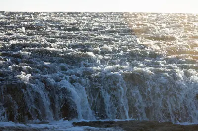 Seawater cascades over the exposed edge of Montgomery Reef as the outgoing tide drains across the reef.