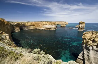 Wide view of limestone sea stacks, cliffs and blue water at Bay of Islands Coastal Park, Victoria.