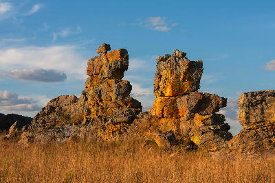 Weathered sandstone rock formations rising above dry grassland in Isalo National Park, Madagascar