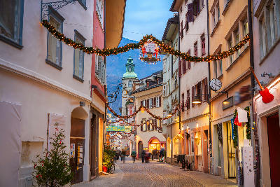 Festive street with Christmas lights in Bolzano old town, South Tyrol, Italy.