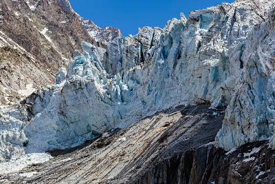 Towering ice walls and crevasses of the Argentière Glacier against rocky alpine slopes in the Mont Blanc Massif, French Alps.