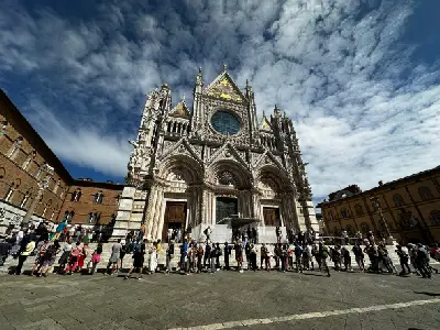 Tourists queuing outside Siena Cathedral (Duomo di Siena) in Piazza del Duomo, Siena, Tuscany, Italy.