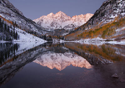 Pre-dawn reflection of snow-covered Maroon Bells in Maroon Lake, Aspen Colorado