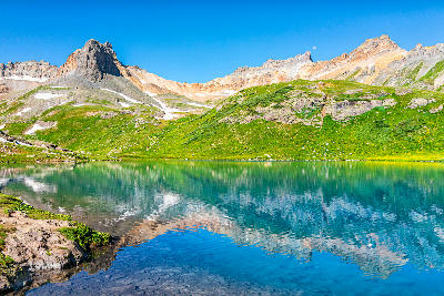Ice Lake with turquoise water reflecting mountain peaks, San Juan Mountains, Colorado.