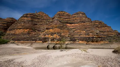 Small remnant pool beneath the striped sandstone walls of the Bungle Bungle Range in the dry bed of Piccaninny Creek.