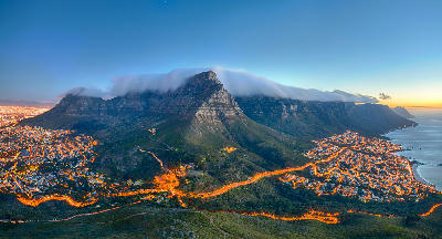 Table Mountain with tablecloth cloud above Cape Town and Camps Bay at sunset, South Africa.