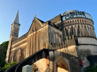 Exterior of Christ Church Cathedral in Stone Town, Zanzibar, featuring its clock tower and distinctive historic architecture.