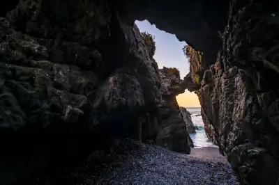 Rock tunnel and natural arch at Duiwenes in Pearl Bay with Atlantic Ocean visible through the opening near Yzerfontein.