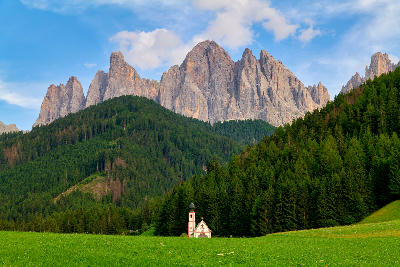 St. Johann in Ranui Church in Val di Funes with the Dolomites mountains behind it, South Tyrol, Italy.