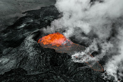 Active lava erupting from the Fagradalsfjall crater on the Reykjanes Peninsula, Iceland, with molten lava flowing and steam rising.