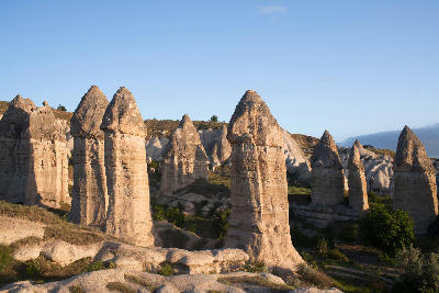 Tall fairy chimneys and pale volcanic rock formations in White Valley, Cappadocia, Turkey.