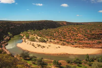 Murchison River curves around a broad sandy bank between red-rock gorge walls and native vegetation below Nature’s Window.