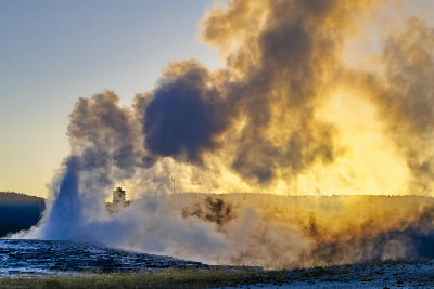 Old Faithful Geyser eruption at sunset Yellowstone National Park steam plume geothermal Wyoming USA