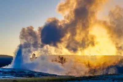 Old Faithful Geyser eruption at sunset Yellowstone National Park steam plume geothermal Wyoming USA