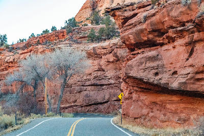 Curving road passing beneath red sandstone cliffs in Grand Staircase–Escalante National Monument, Utah, USA.