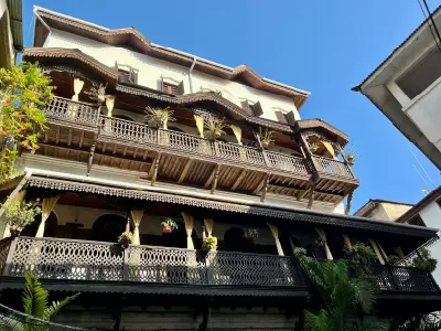 Multi-storey colonial building with ornate carved wooden balconies and Swahili architectural details in Stone Town, Zanzibar.