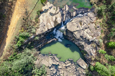 Drone view of the Karkloof River flowing through sandstone rock formations and natural pools surrounded by woodland in the KwaZulu-Natal Midlands, South Africa.