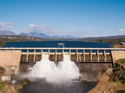 Clanwilliam Dam spillway releasing water into the Olifants River with Cederberg foothills in the background.