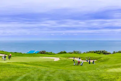 Golfers on the oceanfront fairways of Pinnacle Point Golf Course above coastal cliffs near Mossel Bay, Western Cape, South Africa.