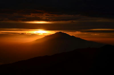 Golden sunset behind Kibo viewed from Shira Camp on Mount Kilimanjaro, Tanzania, at approximately 3,850 metres above sea level, creating a dramatic mountain silhouette.