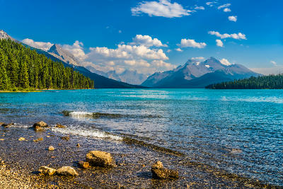 Maligne Lake shoreline with clear turquoise water, rocky foreground, and mountain peaks in Jasper National Park