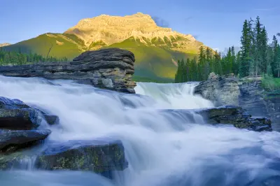 Athabasca Falls flowing over rocky ledges with Mount Kerkeslin in the background at sunset in Jasper National Park, Canada