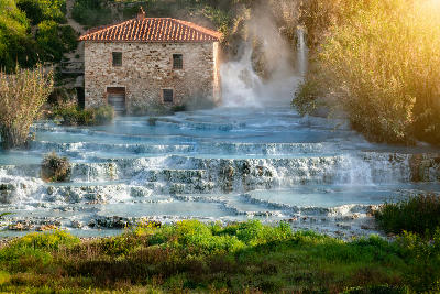 Travertine terraces and cascading thermal pools at Cascate del Mulino hot springs in Saturnia, Tuscany, Italy.