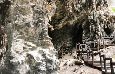 Wooden walkway passing rugged limestone formations near the entrance to Lake Cave in Margaret River.