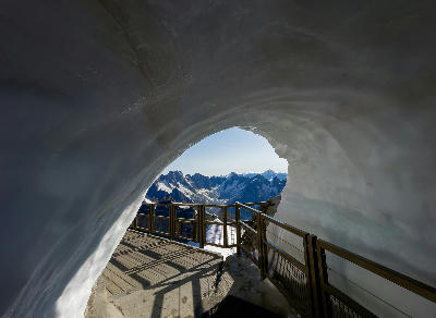 Ice tunnel exit at Aiguille du Midi with view over the Mont Blanc Massif.