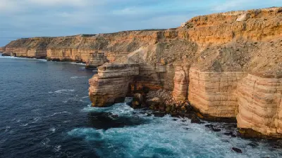 Island Rock rises from the ocean beneath the layered sandstone cliffs of the Kalbarri coast.