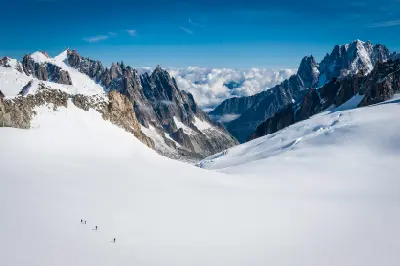 Climbers traversing the wide snow-covered glacier of Vallée Blanche in the Mont Blanc Massif, French Alps.