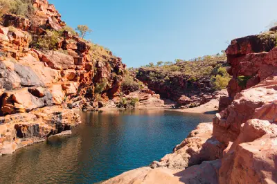 Deep blue pool enclosed by rugged red sandstone walls at Dalmanyi (Bell Gorge) in the Kimberley.
