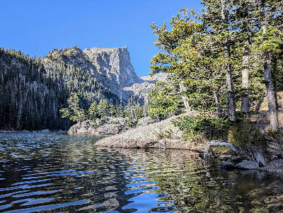 Dream Lake with pine forest and steep mountain cliffs in Rocky Mountain National Park, Colorado.