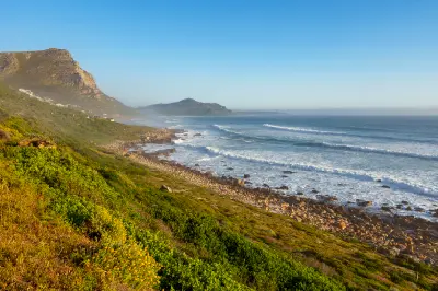 Rocky Atlantic coastline between Scarborough and Misty Cliffs with fynbos-covered slopes and rolling surf along the Cape Peninsula.
