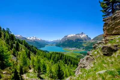 View from hillside above Lake Silvaplana and Lake Sils with forest, alpine valley, and surrounding mountains in the Engadin, Switzerland