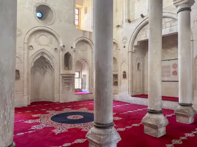 Interior of İshak Pasha Palace with stone columns, carved arches and decorative architectural details near Doğubayazıt, Turkey.