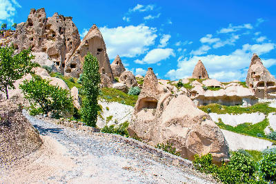 Fairy chimneys with rock-cut pigeon houses along a path in Pigeon Valley, Cappadocia, Turkey.
