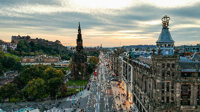 Scott Monument and Princes Street leading toward Edinburgh Castle at sunset in Edinburgh.