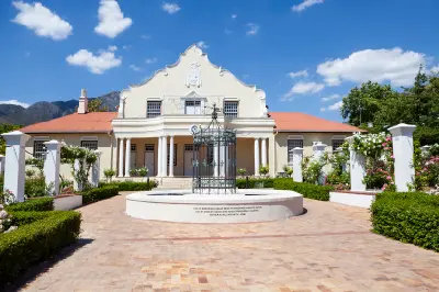 Historic Cape Dutch memorial building with landscaped courtyard in Franschhoek Village, Western Cape, South Africa.